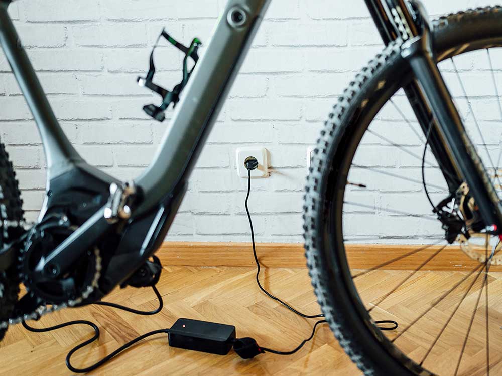 Lithium-ion batteries being charged on an e-bike indoors and on charge